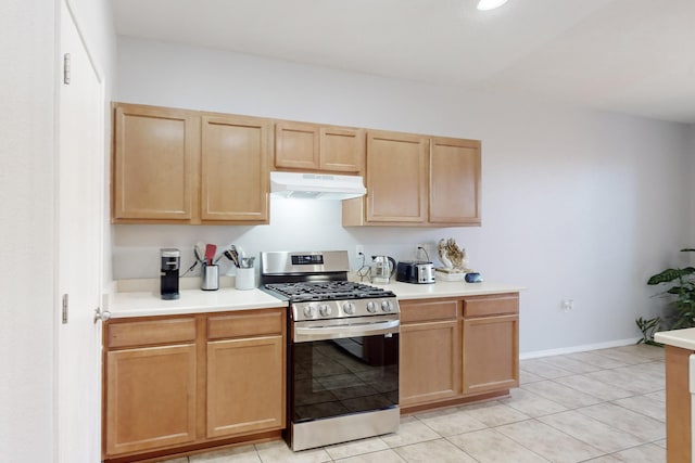 kitchen with light brown cabinetry, gas stove, and light tile patterned floors