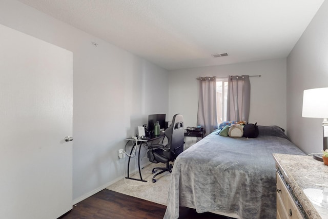 bedroom with dark hardwood / wood-style flooring