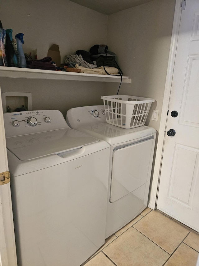 washroom with separate washer and dryer and light tile patterned flooring