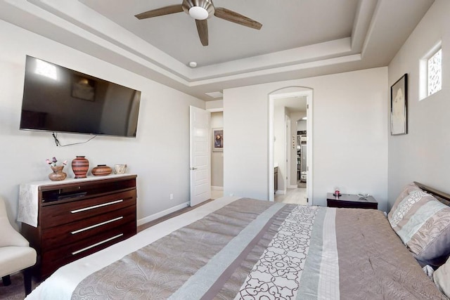 bedroom with ceiling fan and a raised ceiling