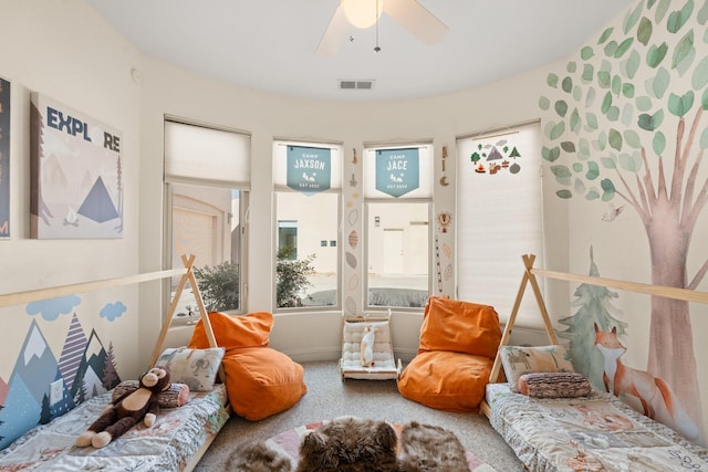 interior space featuring ceiling fan, visible vents, and carpet flooring