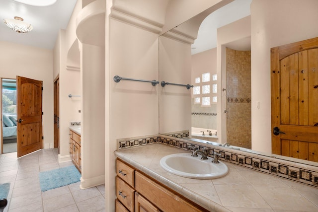 full bath featuring a tile shower, vanity, ensuite bath, and tile patterned floors