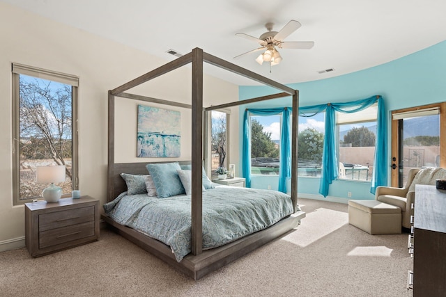 carpeted bedroom featuring a ceiling fan, multiple windows, and visible vents