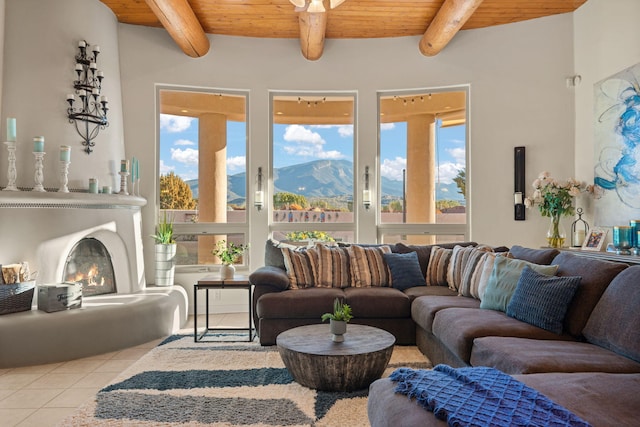 living area featuring a lit fireplace, beamed ceiling, wood ceiling, and tile patterned floors