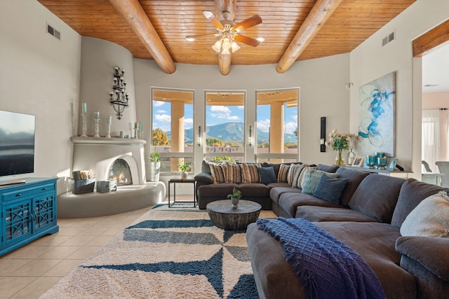 living room with wooden ceiling, visible vents, a lit fireplace, and light tile patterned floors