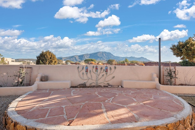 view of patio featuring fence and a mountain view