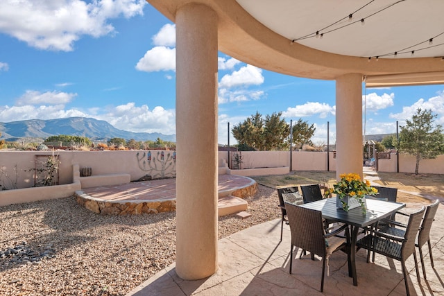 view of patio / terrace with a fenced backyard, a mountain view, and outdoor dining space