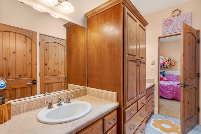 ensuite bathroom with connected bathroom and vanity