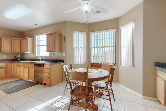 kitchen with light tile patterned floors, sink, ceiling fan, stainless steel dishwasher, and light brown cabinets