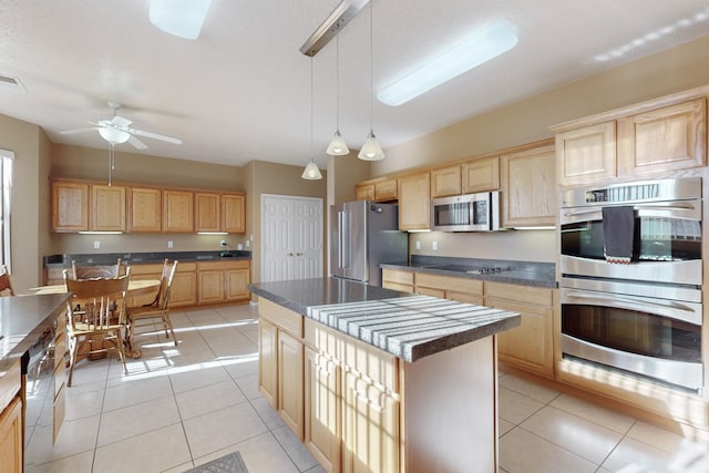 kitchen with light tile patterned floors, light brown cabinets, appliances with stainless steel finishes, and a kitchen island