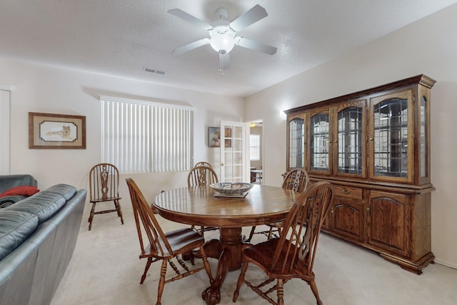 carpeted dining room featuring ceiling fan