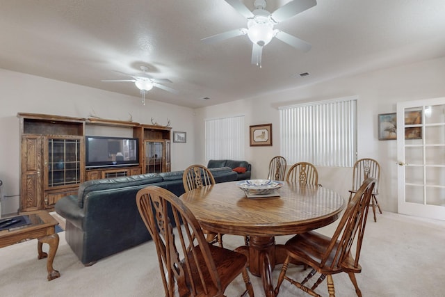 carpeted dining space featuring ceiling fan