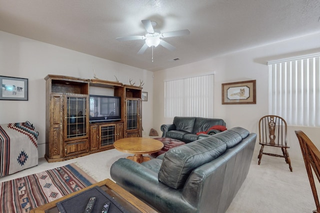 carpeted living room with ceiling fan