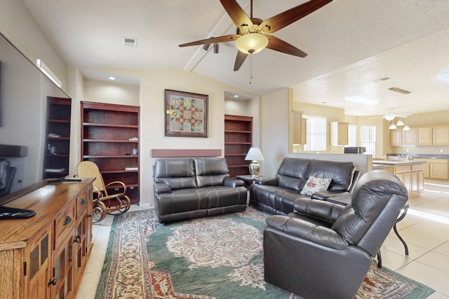 tiled living room featuring lofted ceiling with beams, ceiling fan, and built in shelves