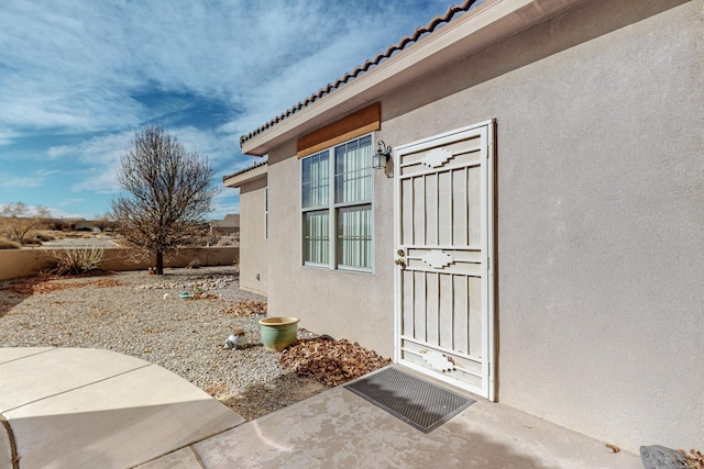 view of exterior entry featuring a patio