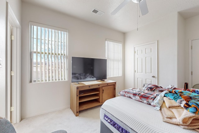 carpeted bedroom featuring a textured ceiling and ceiling fan