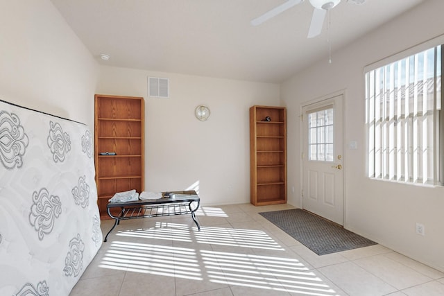 tiled foyer featuring ceiling fan