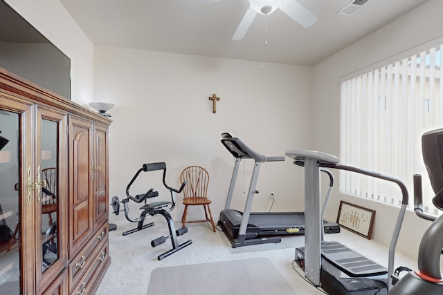 exercise area with ceiling fan and light colored carpet