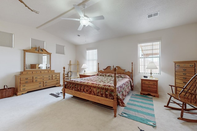 bedroom with lofted ceiling with beams, ceiling fan, carpet flooring, and a textured ceiling