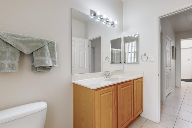 bathroom with tile patterned flooring, vanity, and toilet