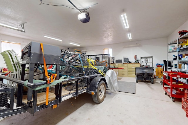 garage with a garage door opener and a workshop area