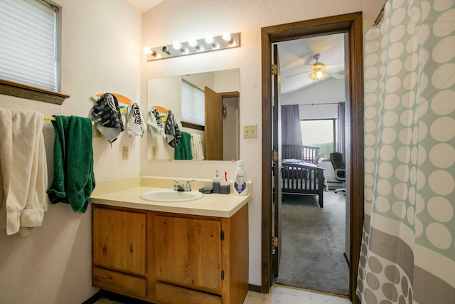 bathroom with ceiling fan, lofted ceiling, and vanity