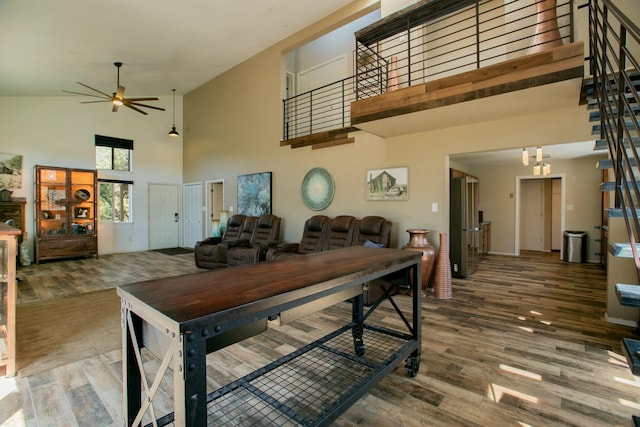 dining area with wood-type flooring, high vaulted ceiling, and ceiling fan