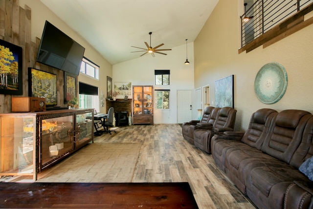 living room featuring a healthy amount of sunlight, ceiling fan, high vaulted ceiling, and wood-type flooring