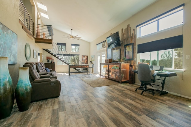 interior space featuring ceiling fan, a towering ceiling, and a healthy amount of sunlight