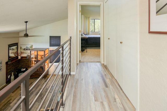 hallway featuring lofted ceiling and light wood-type flooring