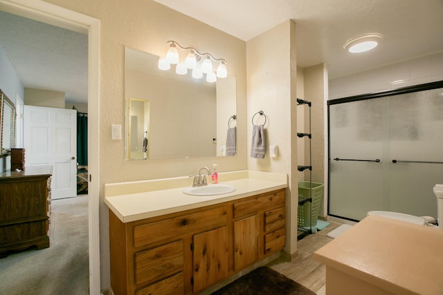 bathroom with a shower with door and vanity