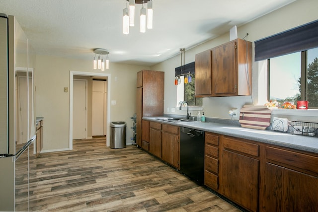 kitchen featuring dishwasher, sink, stainless steel fridge, decorative light fixtures, and dark hardwood / wood-style flooring