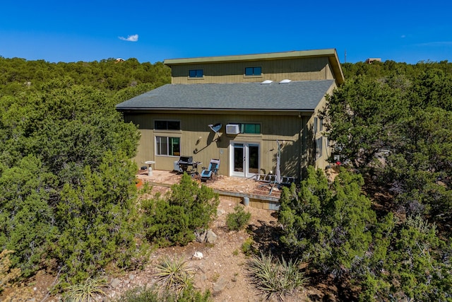 rear view of property with french doors, a wall mounted AC, and a patio area