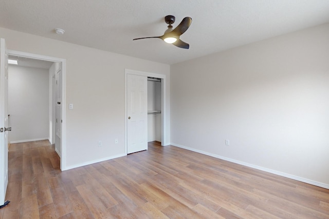 unfurnished bedroom with ceiling fan, a closet, and light wood-type flooring