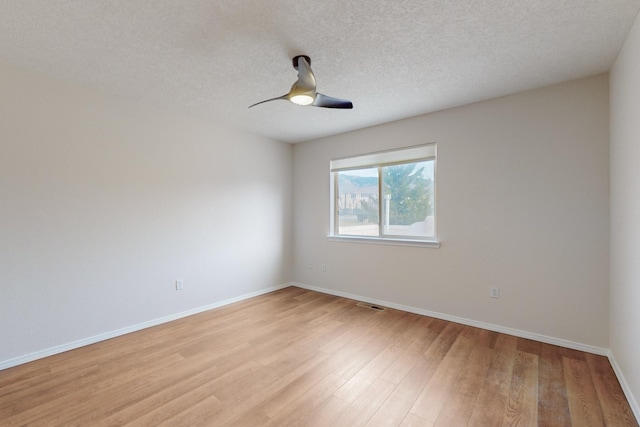 spare room featuring ceiling fan, a textured ceiling, and light wood-type flooring