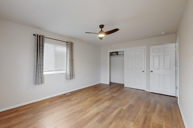 unfurnished bedroom with wood-type flooring, a closet, and ceiling fan