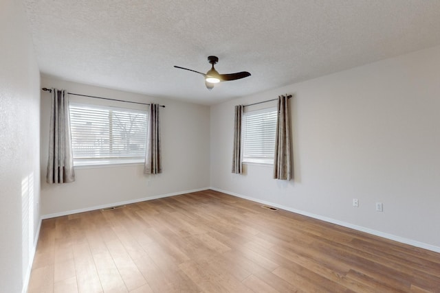 unfurnished room featuring ceiling fan, light wood-type flooring, and a textured ceiling