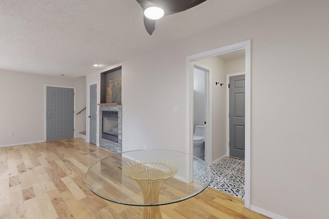 dining area with ceiling fan, wood-type flooring, and a textured ceiling