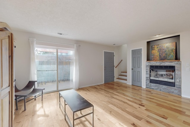 living room featuring a textured ceiling and light hardwood / wood-style flooring