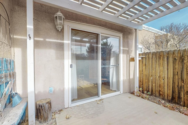 doorway to property featuring a patio area and a pergola