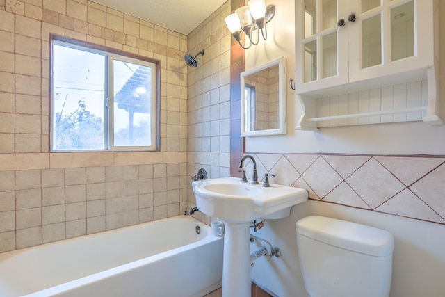 bathroom with tiled shower / bath combo and toilet