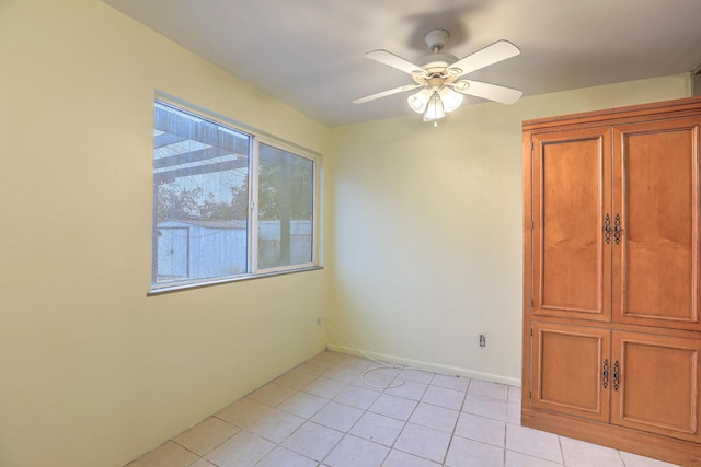 unfurnished room with light tile patterned floors and ceiling fan