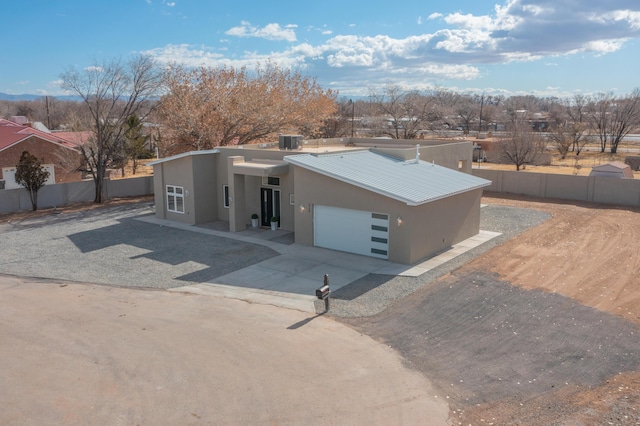 view of front of property with central AC and a garage