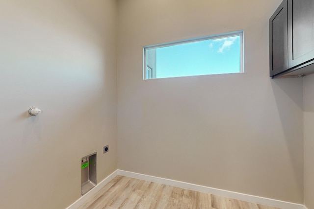 laundry room with light wood-type flooring, electric dryer hookup, and cabinets