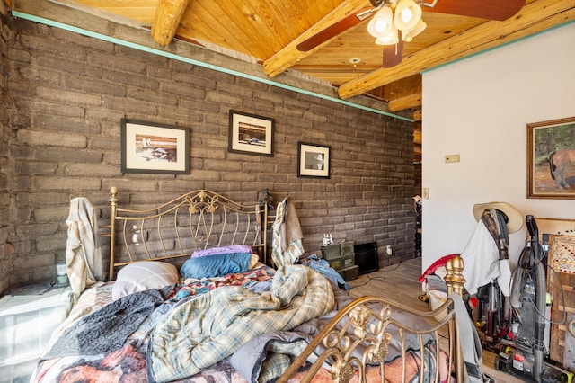 bedroom featuring beamed ceiling, ceiling fan, wooden ceiling, and brick wall