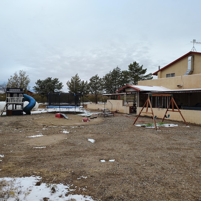 view of yard with a trampoline and a playground