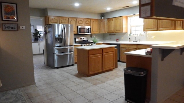 kitchen featuring sink, light tile patterned floors, a kitchen island, and appliances with stainless steel finishes