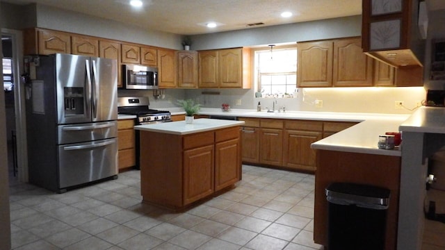 kitchen featuring stainless steel appliances, a kitchen island, and sink