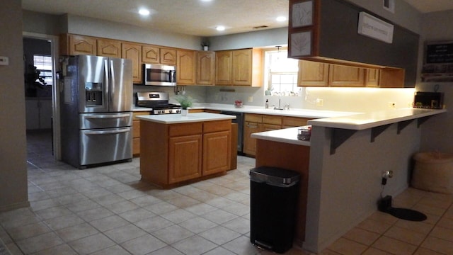 kitchen with light tile patterned floors, sink, stainless steel appliances, and kitchen peninsula