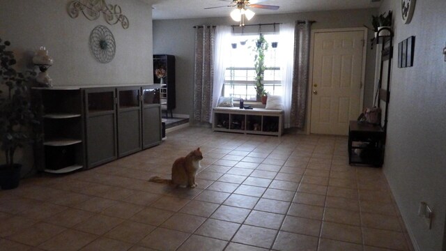 interior space featuring light tile patterned floors and ceiling fan